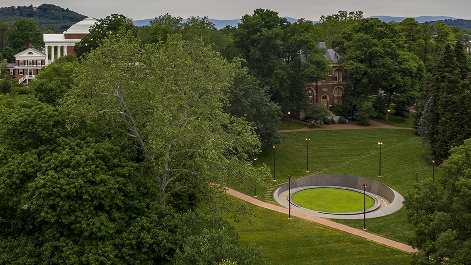 A view of green trees and green lawn, with a path and a sculptural work, which is "Memory Marks" at the Memorial to Enslaved Laborers in Charlottesville, Va.