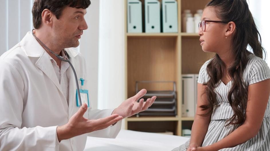 Stock image of a young person speaking to her doctor.
