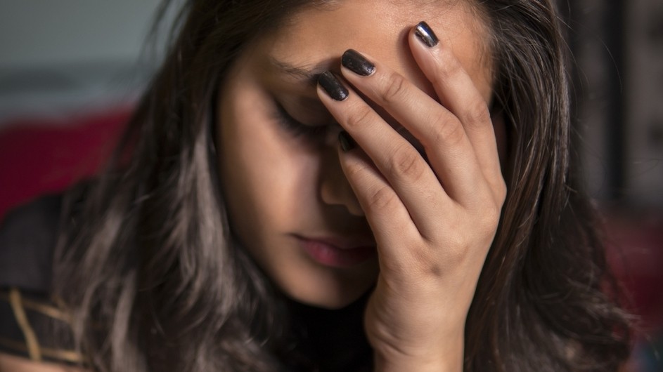 A person holding her head in her hands.