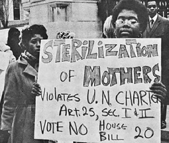 A black and white photo showing women protesting holding up signs.