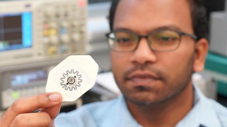 Photo of researcher Rajaram Kaveti holding the water-powered, electronics-free dressing (WPED) for electrical stimulation of wounds.