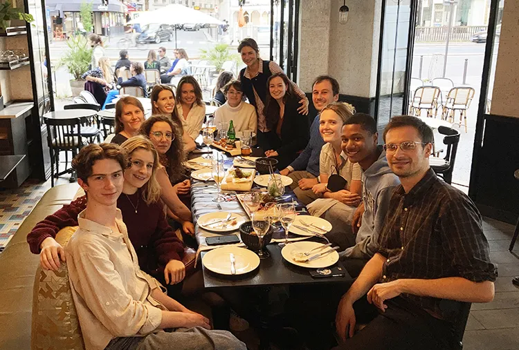 Students sit around a table in Paris, France.