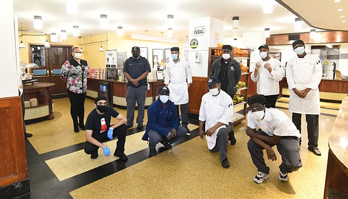 Columbia Dining workers pose in an empty dining hall. 