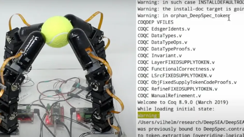 robotic hand gripping tennis ball and computer code telling the hand what to do
