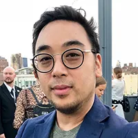 A man with short dark hair and glasses. 