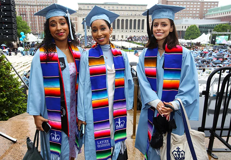 Three grads in Latinx stoles line up in the Academic Procession. 