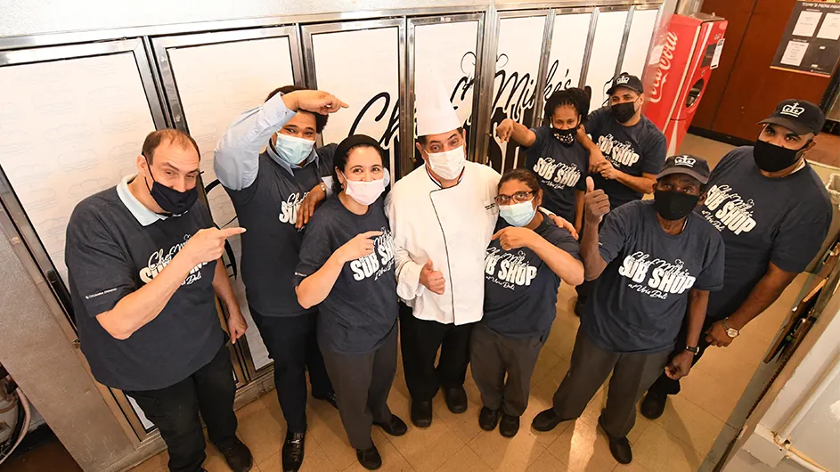 The Columbia Dining Team and Chef Mike pose in front of the Sub Shop. 
