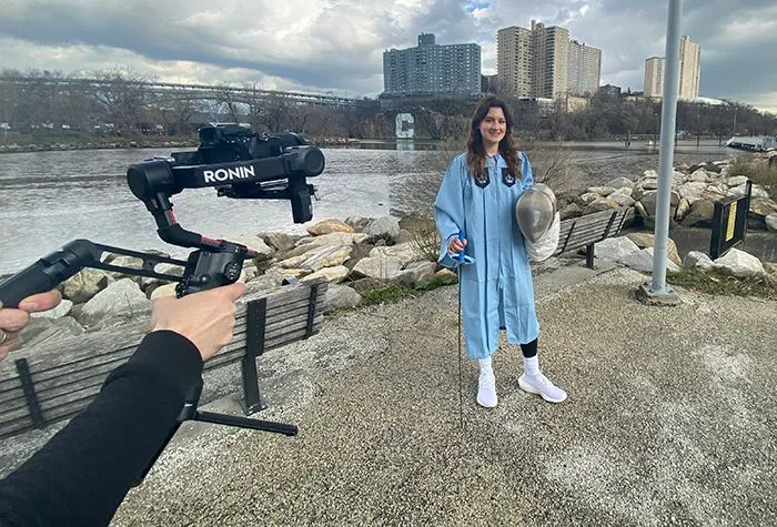 A videographer captures a Columbia fencer in front of the Columbia C. 