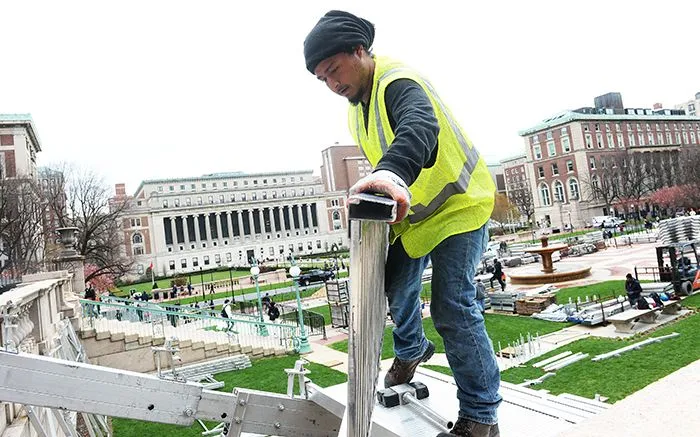 A worker installs bleachers. 