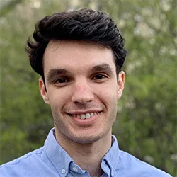 Headshot of Paul Bloom, a person with short dark hair, outside, in a blue shirt. 