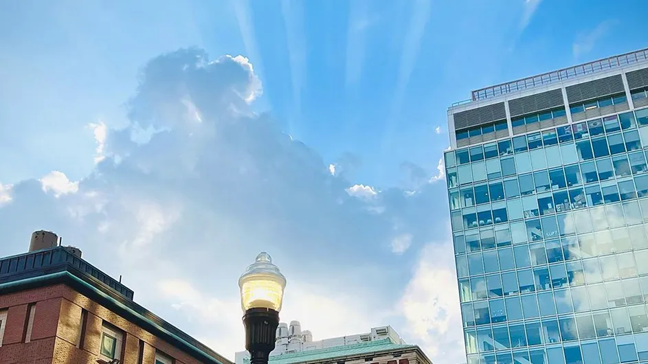 Rays of sunlight illuminate the summer sky behind Columbia's Northwest Corner Building and Havemeyer Hall