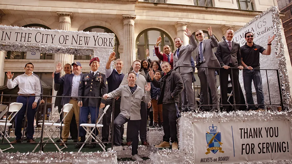 Columbia General Studies military veteran students waving on a parade float with Dean Lisa Rosen-Metsch at the 2021 Veterans Day Parade in New York City.