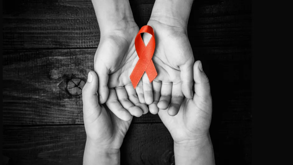 Image of two sets of hands holding each other and a red ribbon symbolizing World AIDS Day