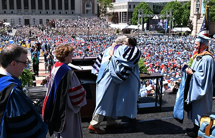 President Bollinger and Minouche Shafik embrace at Commencement. 