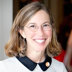 Jeannie Lavine, a woman with medium length light hair and glasses, in a white top. 