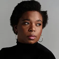 Katori Hall, a woman with short dark hair, in a dark top. 