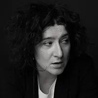 A woman with dark hair in a black and white top. 