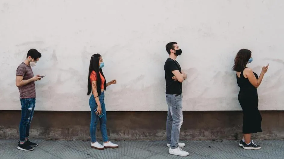 People standing in a line while wearing masks.