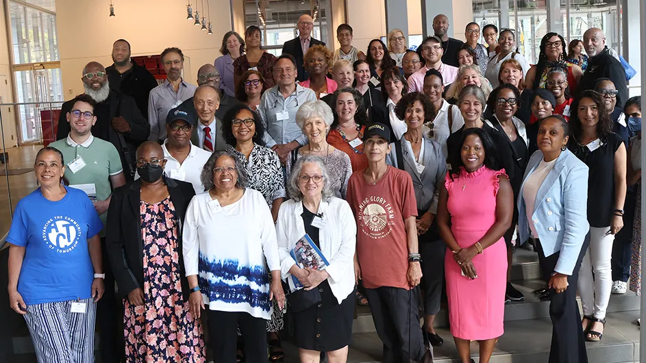 Dozens of Columbia Community Service grantees smile and pose for the camera in the lobby of The Forum at Columbia Manhattanville.