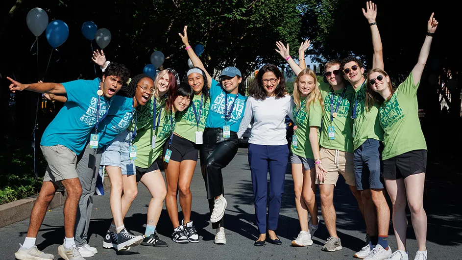Ten students with Columbia President Minouche Shafik smile and cheer as they welcome new students to Columbia University.