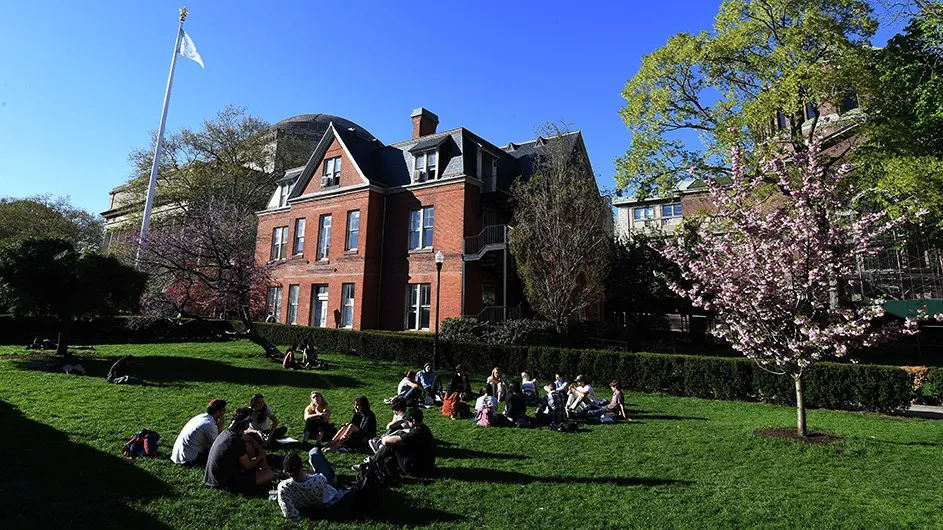 Students sit on the lawn in front of the Maison Francaise on Columbia's Morningside campus.