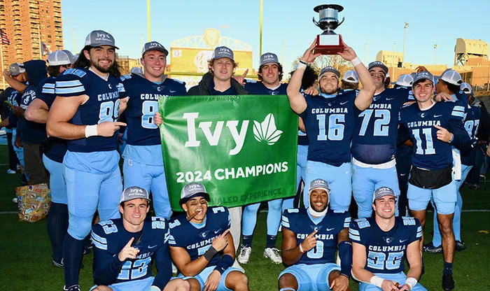 Members of the Columbia Football team pose with the Ivy League Championship trophy.