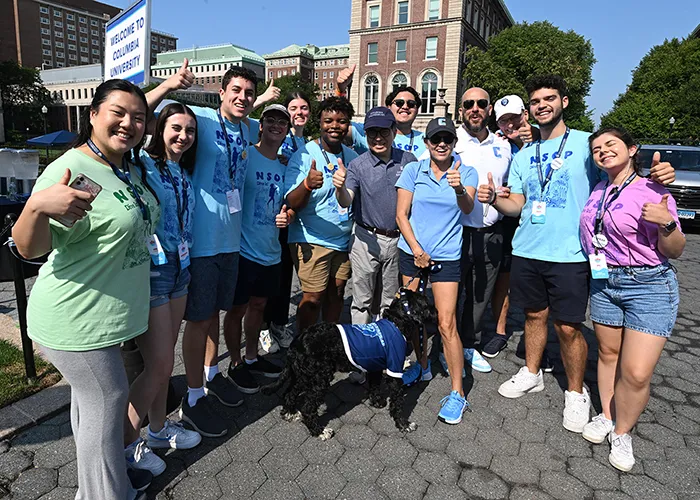 Students gather around Columbia Interim President Katrina Armstrong and her dog on "move-in" day on College Walk