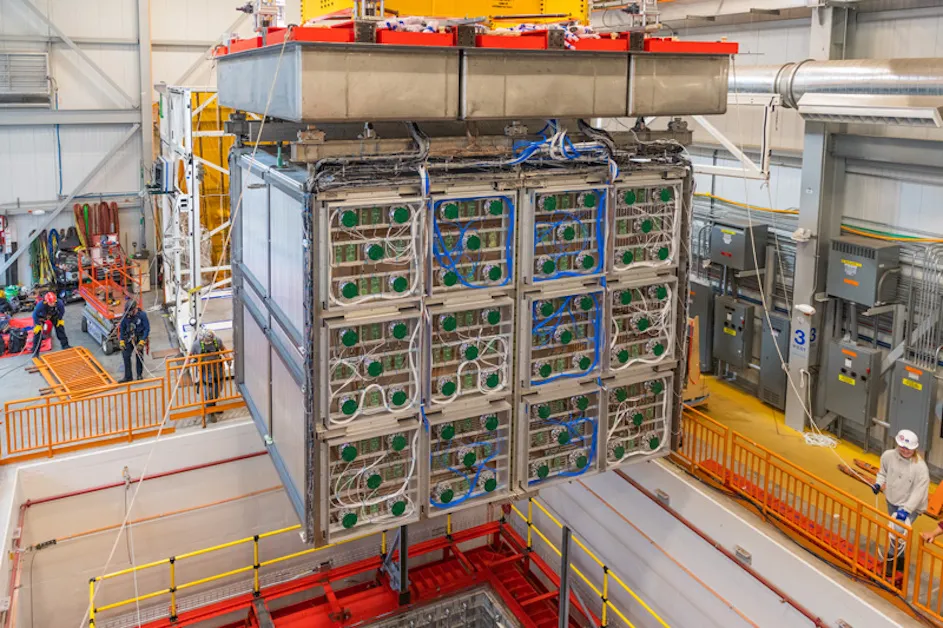 Fermilab technicians and members of the SBND collaboration carefully lower the detector system into the cryostat that will be filled with liquid argon. The move, in April 2023, offered one last glimpse of the wire planes that will enable scientists to record tracks of particles emerging from neutrino collisions.
