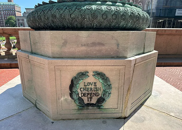 "Love. Cherish. Defend it." reads an inscription at the base of a flag pole. 