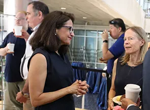 Columbia President Minouche Shafik talking a member of the Operations staff.