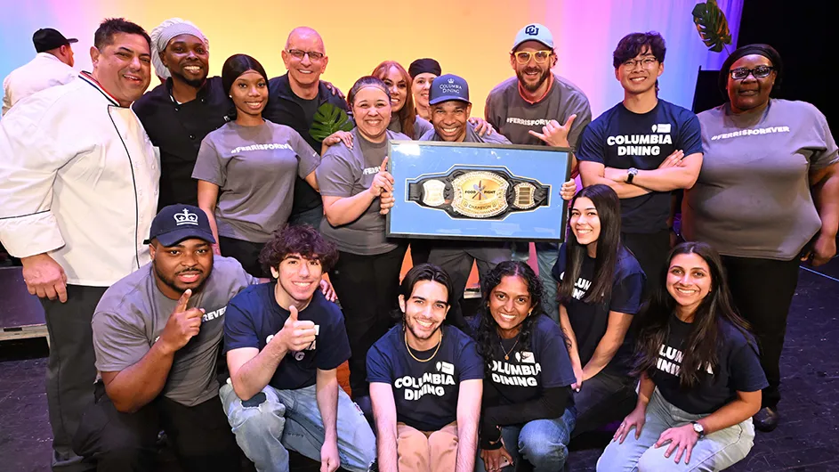 Several students, chefs, and Columbia Dining staff members celebrate and pose with a dining award for top prize in Battle of the Dining Halls at Columbia University.