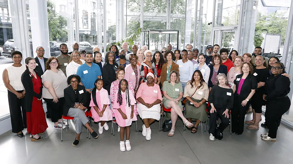 Dozens of Columbia Community Service grantees smile and pose for the camera in the lobby of The Forum at Columbia's Manhattanville campus.