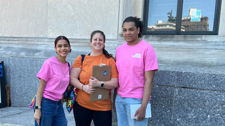 three students stand with a coordinator uptown to get out the vote
