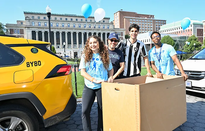 A student meets with NSOP leaders to unload a taxi on Morningside campus. 