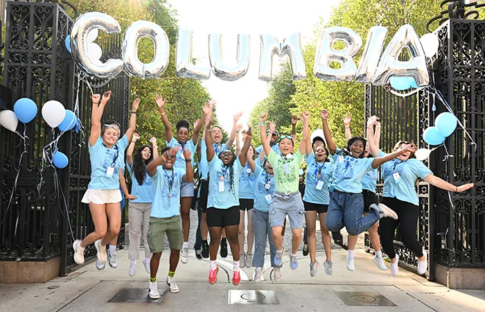 NSOP leaders jump under a "Columbia" banner on College Walk. 