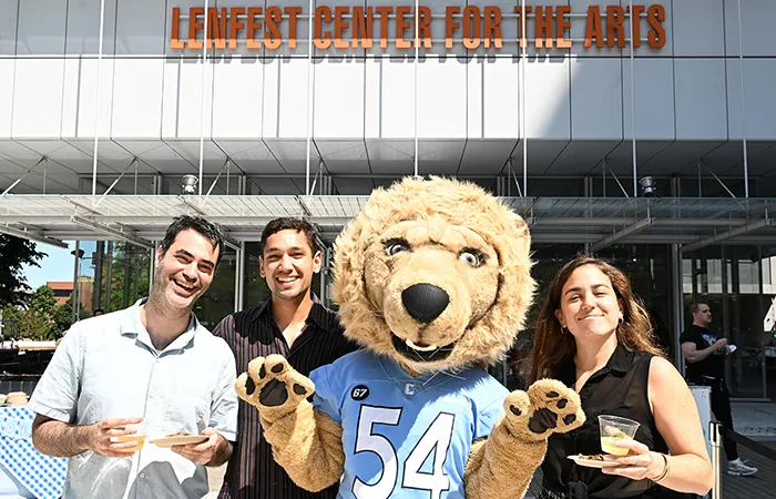 Columbia students on the Manhattanville campus pose in front of Lenfefst Center for the Arts with Roar-EE. 