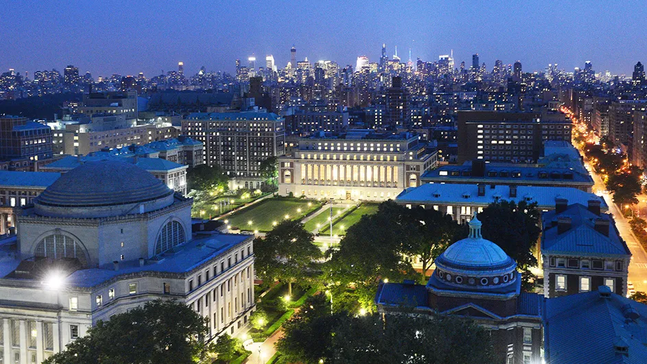 Columbia University campus with New York City skyline at night