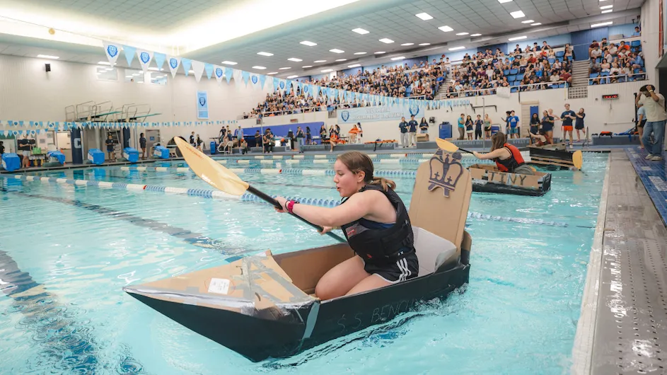 A student rowing in the cardboard regatta