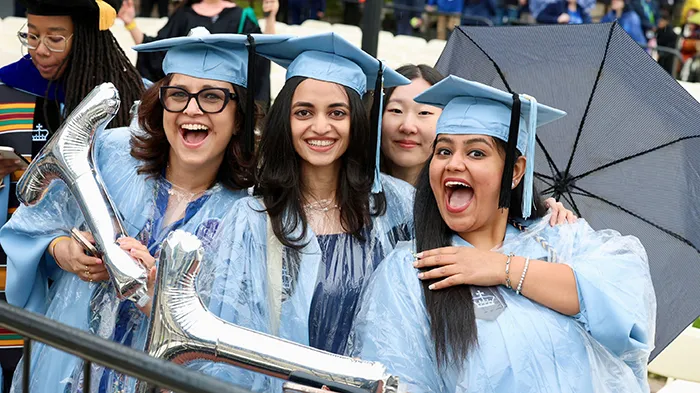 Teachers College grads hold inflatable "T's"