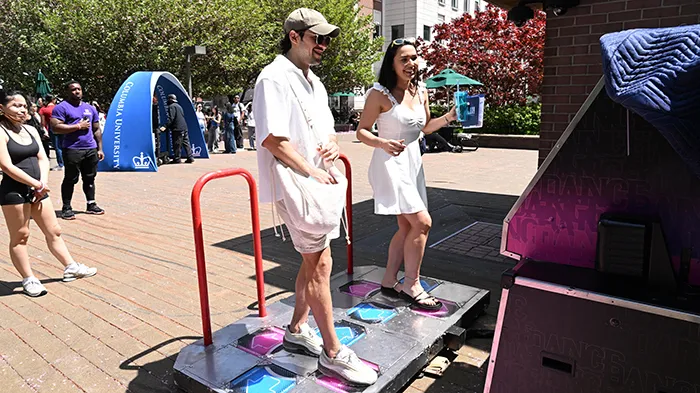 Students standing on a dance video game platform.