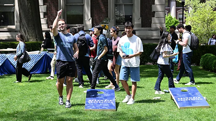 Students play cornhole on a Columbia quad.