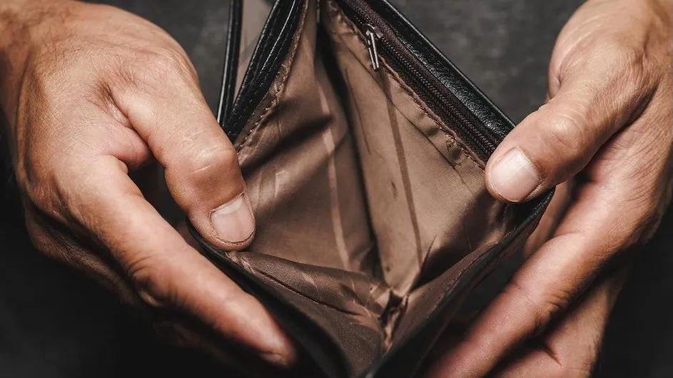 A person looking at an empty wallet.