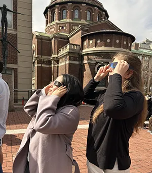 Columbia University student Sara Gomez Horta and wife watch the solar eclipse.