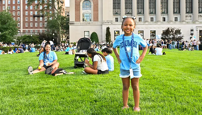 A child in Columbia swag stands proudly on Butler Lawn with her family. 