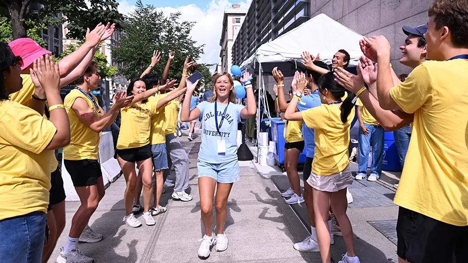 University students cheering as a new student walks near Columbia University