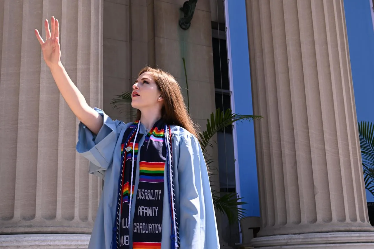 A Columbia wears a stole from the disability affinity graduation and several cords.