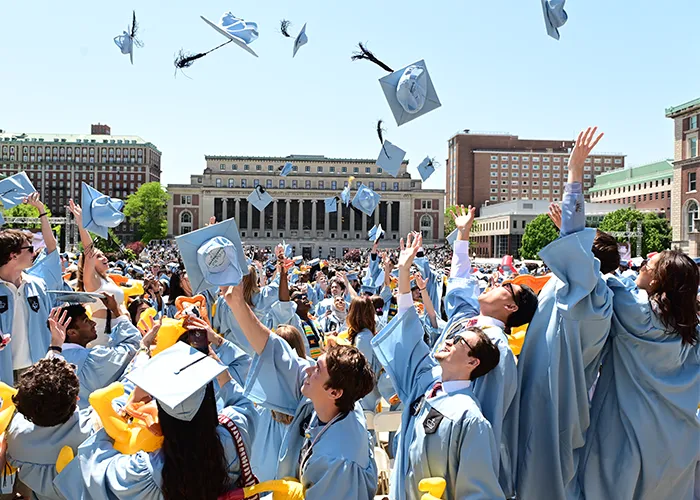 Graduates throw caps in the air.