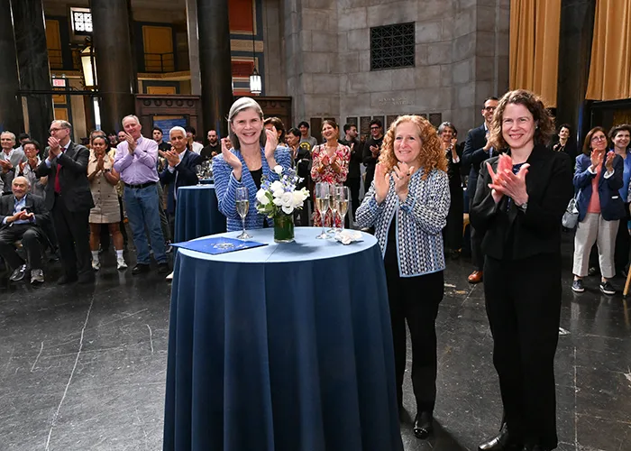 Angela Olinto, Jennifer Mnookin, and Amy Hungerford applaud Michael Woodford.
