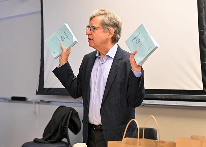 Michael Woodford holds blue books. 