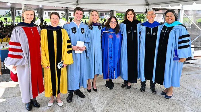 A group of students, faculty, and administrators in academic robes. 